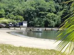 Prainha com píer e barco ancorado